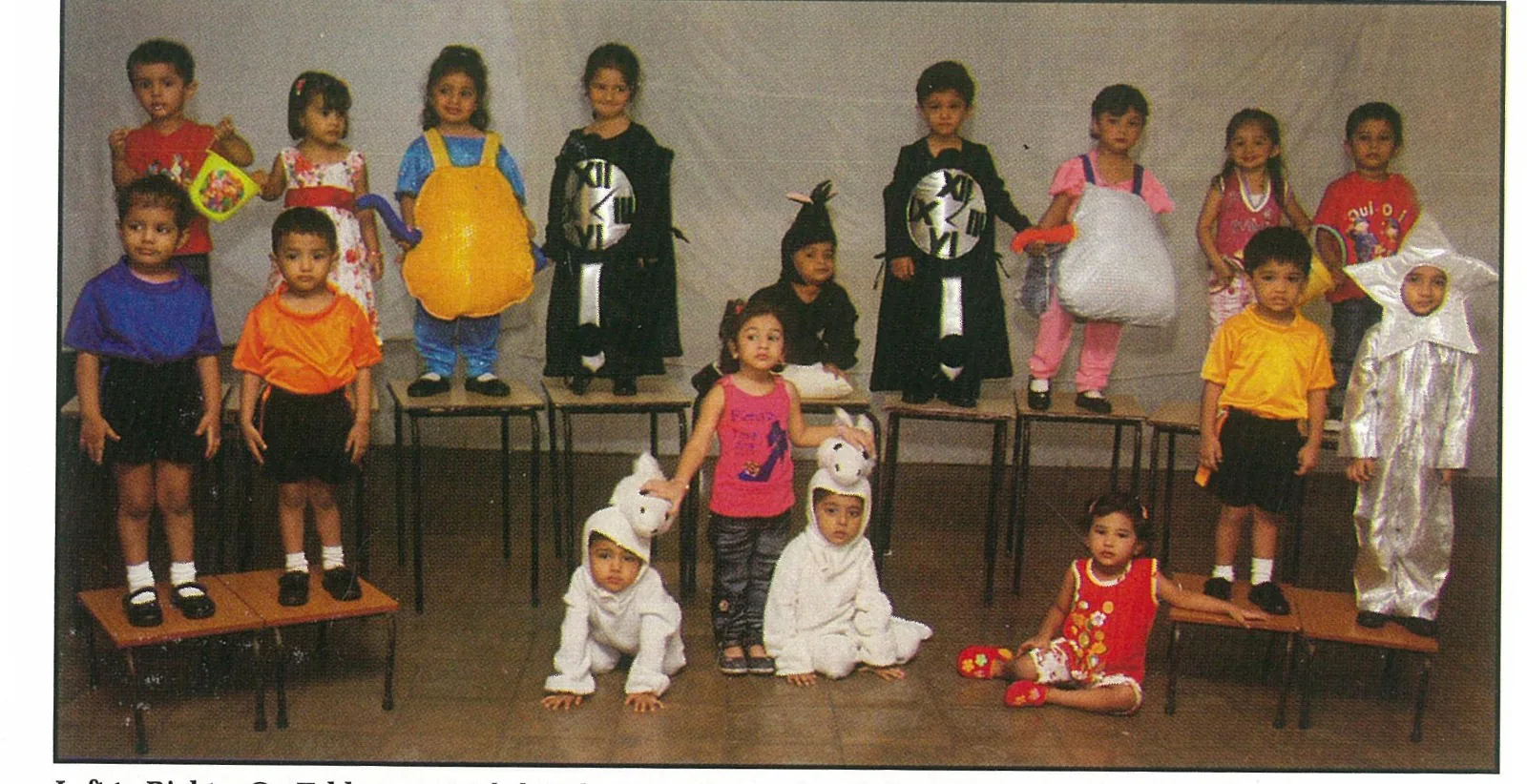 Young NAS children in classroom costumes standing on benches and seated on the floor
