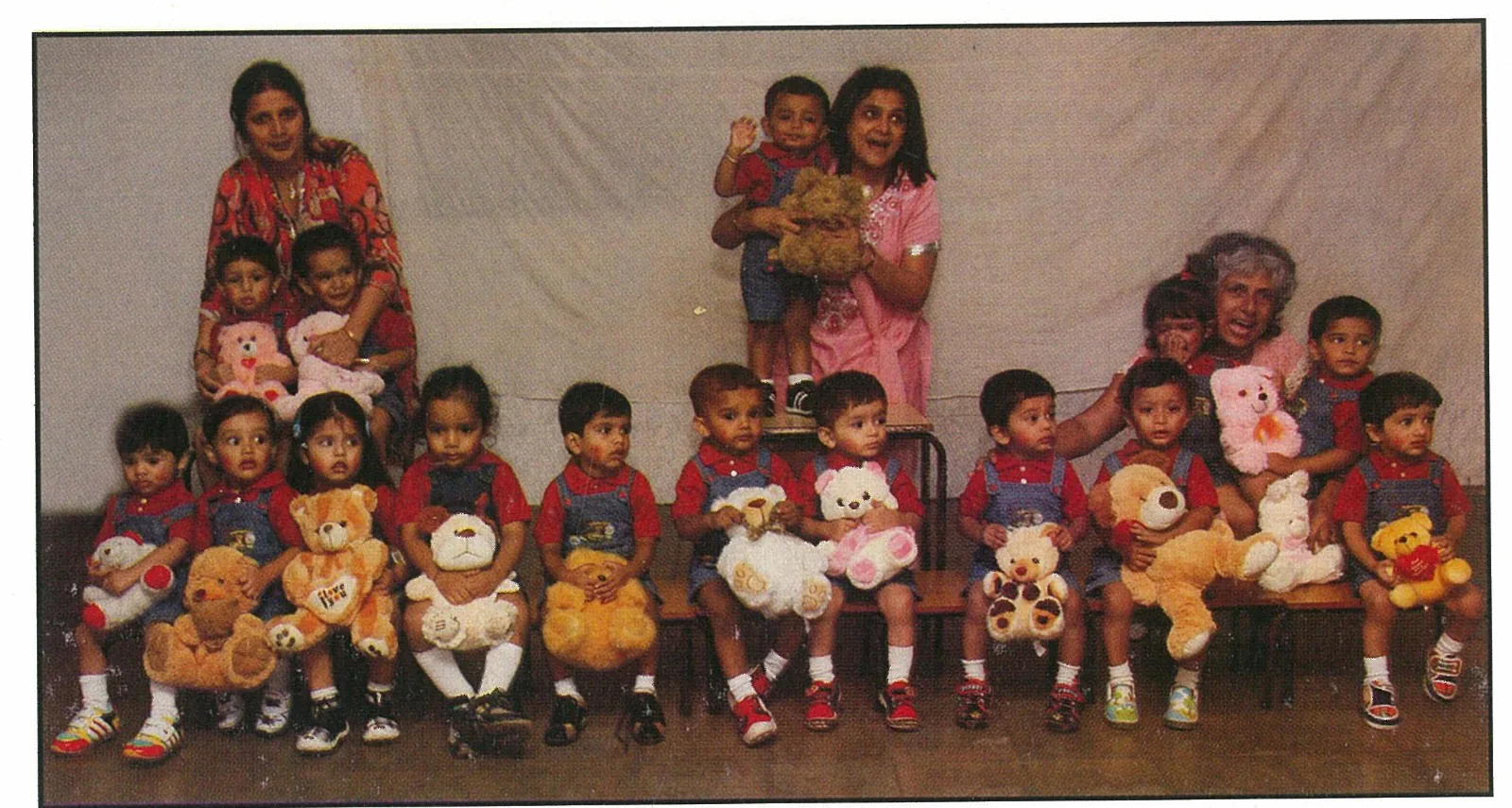 Young NAS children seated with teddy bears and teachers